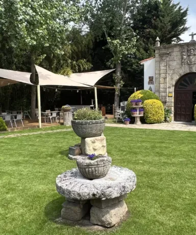 Jardín con carpas, maceteros de piedra y un portón