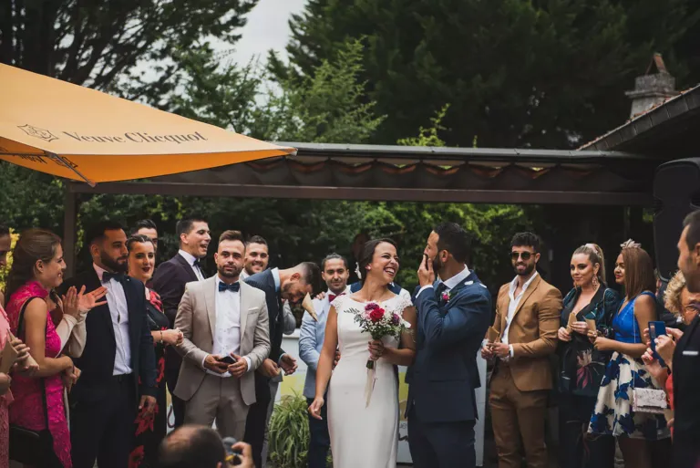 Pareja de novios rodeada de invitados a su boda